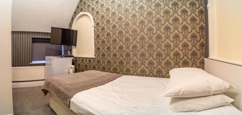 a hotel room with a bed and a tv at Quayside Hotel & Bar in Boston