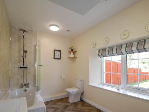 une salle de bain avec douche et toilettes et une fenêtre dans l'établissement North Cottage, à Glenelg