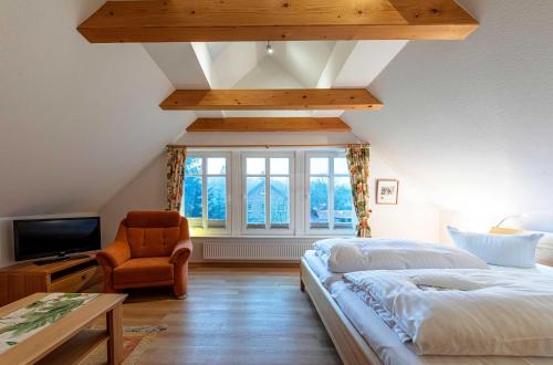 una camera da letto con un letto, una sedia e una finestra di Havelquelle mit Sauna und Garten a Kratzeburg