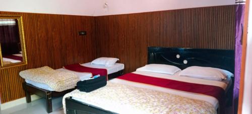 two beds in a room with red walls at Aayana Valley in Chikmagalur