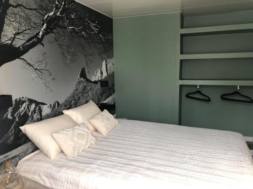 une chambre avec un lit avec un tableau sur le mur dans l'établissement L'Appart', à Chambon-sur-Lac