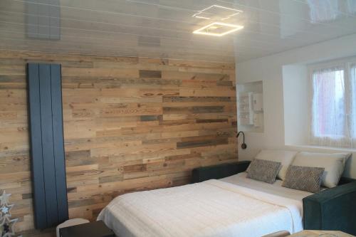 - une chambre avec un mur en bois et un lit dans l'établissement L'Appart', à Chambon-sur-Lac