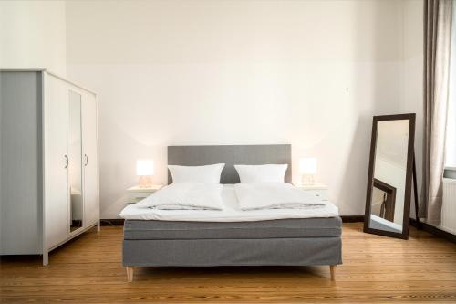 a bedroom with a bed with two lamps and a mirror at InselLiebe mit Seeterrasse in Malchow