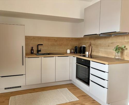 a kitchen with white cabinets and a counter top at GIPFELGLÜCK - Ferienwohnung zentral in Nesselwang in Nesselwang