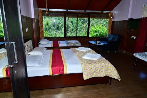 two beds in a room with a window at Aayana Valley in Chikmagalur