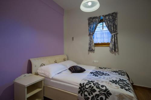 a small bedroom with a bed and a window at Butorowy Dwór in Kościelisko