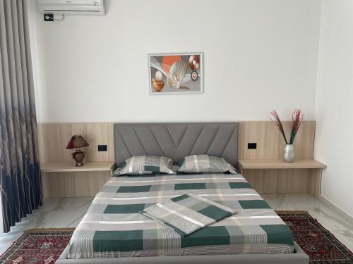 a bedroom with a large bed with two pillows at Vila BriArt in Durrës