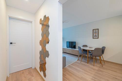 una stanza con un tavolo, delle sedie e una porta di Luminious apartment with balcony by Polo Apartments a Kaunas