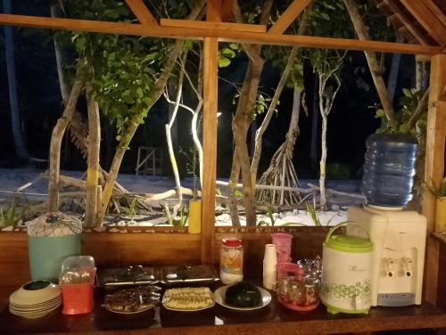 a counter top with plates and bowls of food at Marlina Homestay in Fam