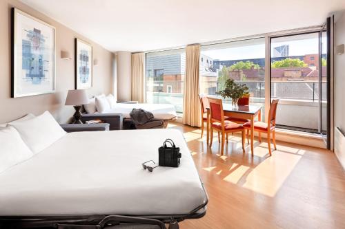 a hotel room with a bed and a table and chairs at Marlin Apartments London Bridge - Empire Square in London
