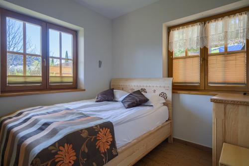 a bedroom with a bed with two pillows on it at Butorowy Dwór in Kościelisko
