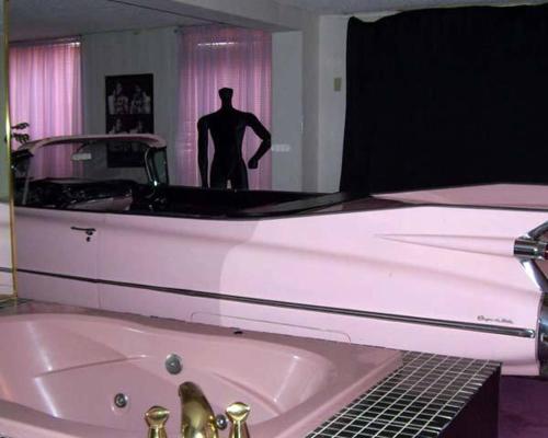 a man standing in front of a bath tub in a bathroom at Red Carpet Inn Fanta Suites Hotel in Greenwood