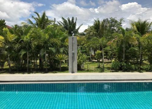 ein Schwimmbad vor einem Haufen Palmen in der Unterkunft Diamond Villas in Ban Phang Phrao