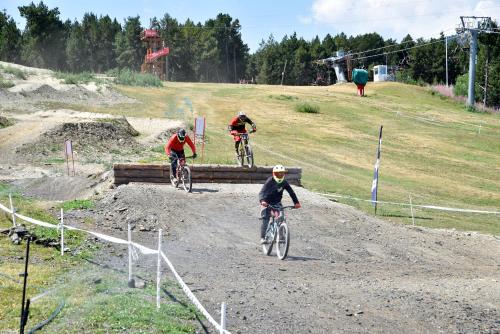 three people riding bikes on a dirt road at NH Collection Andorra Palomé in La Massana