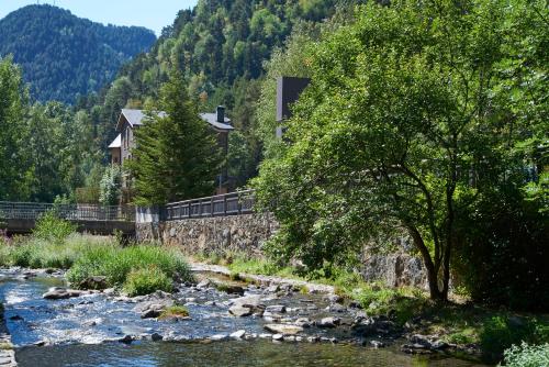 a house on a bridge over a river at NH Collection Andorra Palomé in La Massana