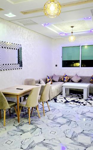 a living room with a couch and a table and chairs at Fes Serenity - Appartement Suites Medina in Fès