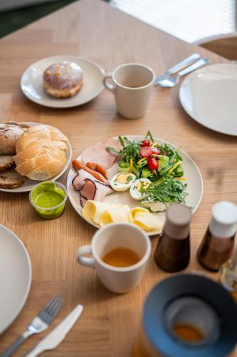 een houten tafel met borden met eten erop bij Apartament SAIL SurfingBird Dźwirzyno in Dźwirzyno