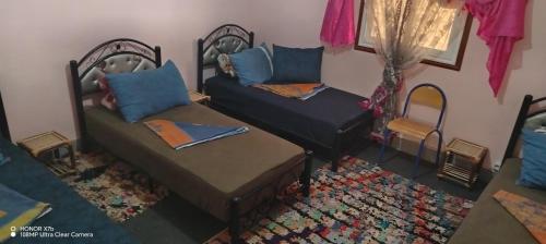 a living room with two beds and a couch at Ouarzazate Youth Hostel YHO in Ouarzazate