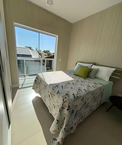 a bedroom with a bed and a large window at Casa linda com piscina e Bem Próximo ao Parque in São Lídio