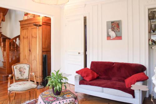 - un salon avec un canapé rouge et une chaise dans l'établissement Family duplex - with balcony, à Paris