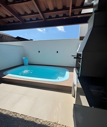 a hot tub on the deck of a house at Casa linda com piscina e Bem Próximo ao Parque in São Lídio