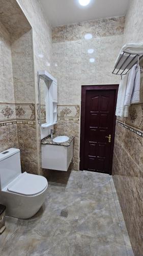 a bathroom with a toilet and a sink and a door at Grandview Boutique Hotel in Baku