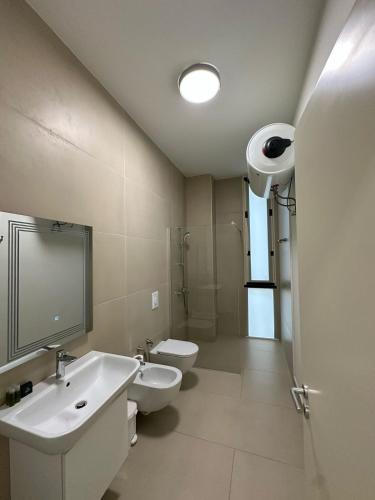 a bathroom with two toilets and a sink and a shower at Whisky Green Coast Hotel & Apartments in Palasë
