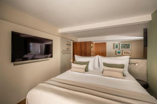 a bedroom with a large white bed with pillows at Girandella Resort, Valamar Collection in Rabac
