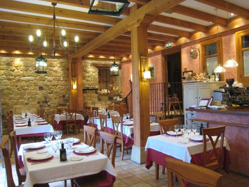 a restaurant with white tables and chairs in a room at Posada Las Mayas in Quintanar de la Sierra