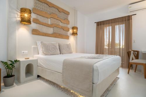 a bedroom with a large white bed in a room at Villa Kelly Rooms & Suites in Naousa