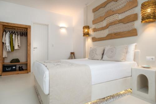 a bedroom with a white bed and a closet at Villa Kelly Rooms & Suites in Naousa