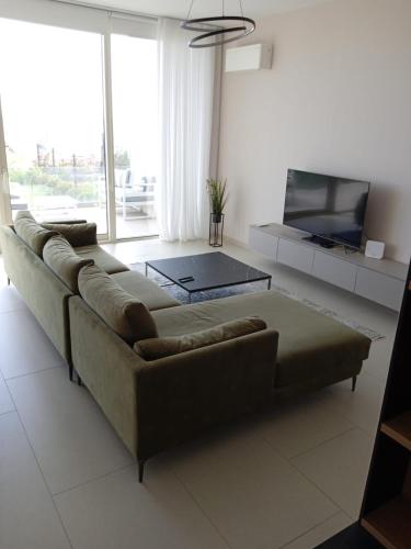 a living room with a couch and a flat screen tv at Whisky Green Coast Hotel & Apartments in Palasë