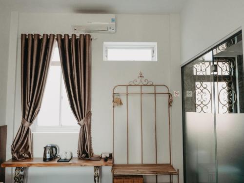 a room with curtains and a table and a window at LA MER Homestay Quynhon in Quy Nhon