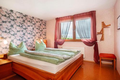 a bedroom with a bed and a window at Ferienhaus am Ried in Burgweiler