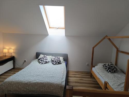 a bedroom with two beds and a window at Apartamenty Marta i Michał Dziwnówek in Dziwnówek