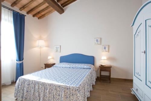 a bedroom with a blue bed and two lamps at Casale San Galgano in Chiusdino