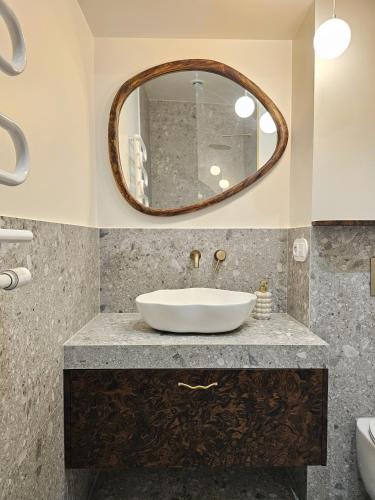 a bathroom with a sink and a mirror at Wine Apartments in Kraków