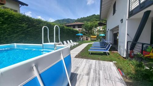 a pool with surfboards on the side of a house at Appartamenti Lilia - Ledro in Tiarno di Sopra