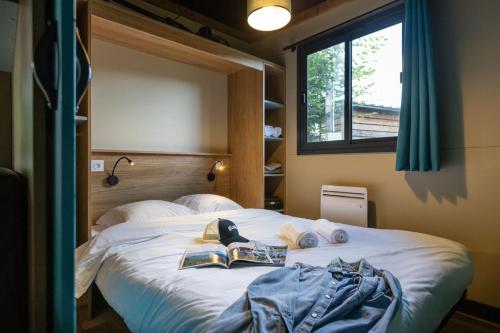 une chambre avec un grand lit blanc avec une fenêtre dans l'établissement CityKamp Angers, à Angers