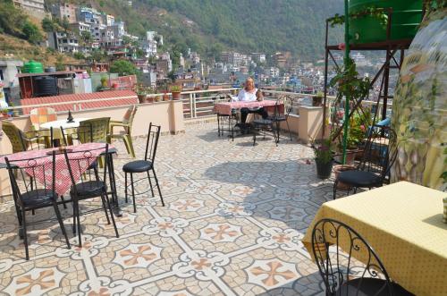 Una mujer sentada en una mesa en lo alto de un patio. en Touri House, en Katmandú