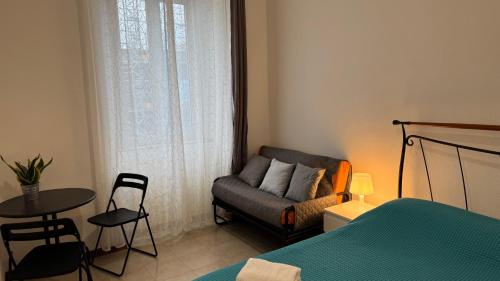 a bedroom with a bed and a couch and a table at A Casa di Cleo in Trieste
