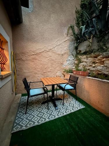 - une table de pique-nique et 2 chaises sur la terrasse dans l'établissement Cozy home near Carcassonne, à Aragon