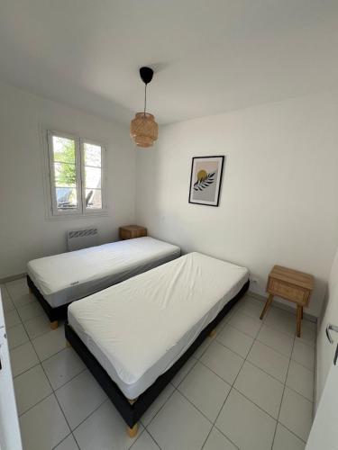 une chambre avec deux lits et une fenêtre dans l'établissement Cozy home near Carcassonne, à Aragon