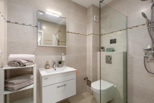 a bathroom with a shower and a toilet and a sink at Modern apartment Zen with private garden in Poreč