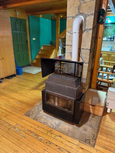 a wood stove in a room with a staircase at Čarobna kućica in Mitrovac