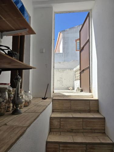 a room with a window with a cat laying on the stairs at Paraíso Escondido in Alte