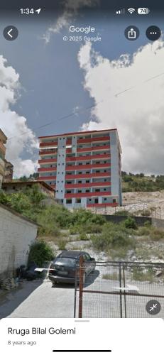 a car parked in a parking lot in front of a building at Apartament Drasa in Gjirokastër