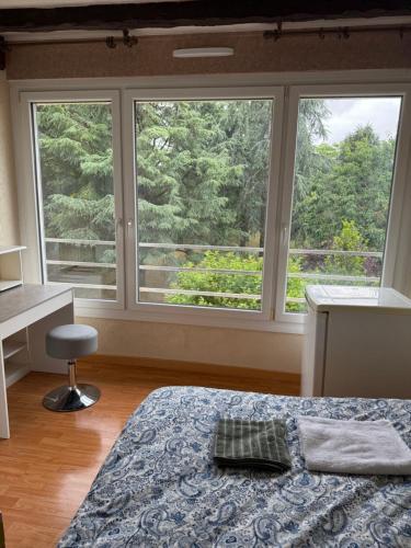 une chambre avec un lit et deux grandes fenêtres dans l'établissement résidence Agen2, à Saint-Herblain