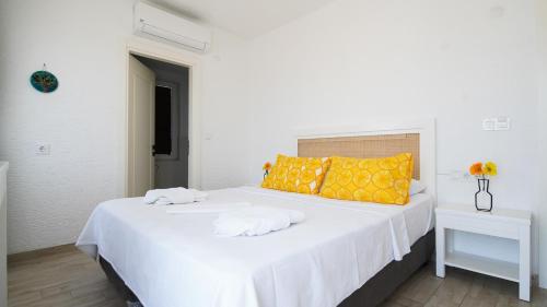 a white bed with two towels on top of it at Limonata Bozcaada ex Vina Garden in Bozcaada