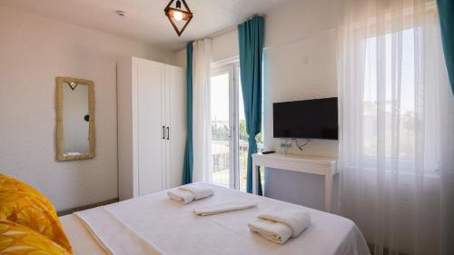a bedroom with a bed with towels on it at Limonata Bozcaada ex Vina Garden in Bozcaada